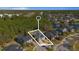 Aerial view of a beautiful blue home with lush green trees surrounding it in a serene neighborhood near a lake at 376 Chelsea Place Ave, Ormond Beach, FL 32174