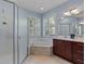 Bright bathroom with a corner tub, walk in shower, and a large mirror at 376 Chelsea Place Ave, Ormond Beach, FL 32174