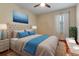 Bright bedroom features a tufted headboard, blue accents, and a ceiling fan at 376 Chelsea Place Ave, Ormond Beach, FL 32174