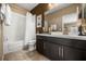 Well-lit bathroom featuring a shower and tub combo, and a dark vanity with a white countertop at 3955 Equine Cv, Lake Mary, FL 32746