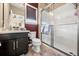 Bright bathroom featuring a glass-enclosed shower, a toilet, and a vanity with a white countertop at 3955 Equine Cv, Lake Mary, FL 32746