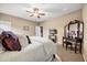 Inviting bedroom with neutral walls, and carpet, a ceiling fan, large bed, and an antique vanity at 3955 Equine Cv, Lake Mary, FL 32746