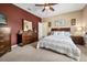 Comfortable bedroom featuring neutral carpet, a queen bed, a large window, and a wooden dresser with mirror at 3955 Equine Cv, Lake Mary, FL 32746