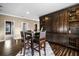 Open dining area featuring a wooden table set and a custom-built wooden bar with shelving and stylish cabinets at 3955 Equine Cv, Lake Mary, FL 32746