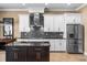Modern kitchen with white cabinets, a stainless steel refrigerator, and a mosaic tile backsplash at 3955 Equine Cv, Lake Mary, FL 32746