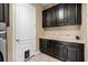 Functional laundry room with dark cabinets, light countertops, and convenient pet door at 3955 Equine Cv, Lake Mary, FL 32746