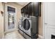 Laundry room featuring side-by-side washer and dryer, tile flooring, a window, and storage cabinets at 3955 Equine Cv, Lake Mary, FL 32746