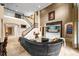 Grand living room with soaring ceilings, elegant staircase, and a sleek black leather sectional sofa at 3955 Equine Cv, Lake Mary, FL 32746