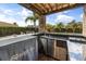 Outdoor kitchen and bar area with stainless steel appliances and granite countertops overlooking the pool at 3955 Equine Cv, Lake Mary, FL 32746
