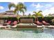 Backyard pool and jacuzzi with lounge seating and a decorative waterfall surrounded by lush landscaping at 3955 Equine Cv, Lake Mary, FL 32746