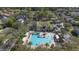 Beautiful aerial view of the pool area, which has a pool, clubhouse, lounge chairs, and many trees at 406 Ravenshill Way, Deland, FL 32724