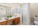 Bathroom featuring a double vanity, framed mirror, and glass shower at 406 Ravenshill Way, Deland, FL 32724