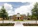 A charming community clubhouse has great curbside appeal and a lush green median in the parking area at 406 Ravenshill Way, Deland, FL 32724