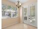 Bright dining area with chandelier, tiled floor, and glass doors to the lanai at 406 Ravenshill Way, Deland, FL 32724