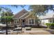 Charming tan home featuring a manicured front yard with beautiful landscaping and a pathway to the front door at 406 Ravenshill Way, Deland, FL 32724
