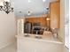 Open kitchen with stainless steel appliances, breakfast bar, and tiled floor at 406 Ravenshill Way, Deland, FL 32724