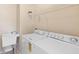 Bright laundry room with washer, dryer, utility sink, and storage shelf at 406 Ravenshill Way, Deland, FL 32724
