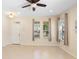 Bright living room with tiled floors, neutral walls, a ceiling fan, and natural light from multiple windows at 406 Ravenshill Way, Deland, FL 32724