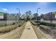 Tennis courts in the community feature lampposts, trees, and a shaded walkway at 406 Ravenshill Way, Deland, FL 32724