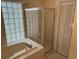 Bathroom features a garden tub, glass enclosed shower, neutral tiled floors and a privacy glass window at 4164 New Marsh Rd, Deland, FL 32724