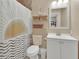 Charming bathroom featuring a decorative shower curtain, built-in shelving and a classic vanity at 427 E Church St, Deland, FL 32724