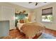 Cozy bedroom with hardwood floors, a decorative headboard and warm, natural light from the window at 427 E Church St, Deland, FL 32724
