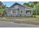 Charming home with a covered porch, side yard and palm trees at 427 E Church St, Deland, FL 32724