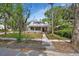 Charming gray two-story home with a metal roof, inviting front yard, and picturesque trees at 427 E Church St, Deland, FL 32724