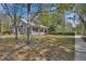 A charming gray home with a metal roof with a well-manicured lawn and mature trees at 427 E Church St, Deland, FL 32724