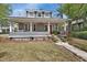 Inviting front porch with a porch swing, a red door, and charming landscaping at 427 E Church St, Deland, FL 32724