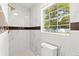 Modern bathroom featuring marble walls, gold fixtures, and a window for natural light at 4333 Arch St, Orlando, FL 32808