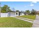 Charming exterior featuring a well-maintained lawn, driveway, and partial fence in a bright daytime setting at 4333 Arch St, Orlando, FL 32808