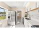 Galley kitchen with stainless steel refrigerator, granite countertops, and white cabinets at 4333 Arch St, Orlando, FL 32808