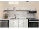 Updated kitchen showcases white cabinets, stainless steel appliances, quartz countertops and luxury finishes at 4333 Arch St, Orlando, FL 32808