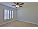 Bedroom featuring a ceiling fan, neutral paint, tile flooring, and plantation shutters at 437 Merrimac Dr, Port Orange, FL 32127
