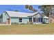 Charming single-story home features a metal roof, screened-in porch, garage and fresh green lawn at 437 Merrimac Dr, Port Orange, FL 32127