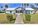 Inviting single-story home with a screened-in porch, manicured lawn, and a charming sidewalk entrance at 437 Merrimac Dr, Port Orange, FL 32127