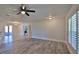 Bright living area with wood-look floors leading to a kitchen and an enclosed porch with neutral decor at 437 Merrimac Dr, Port Orange, FL 32127