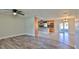 Open-concept living space with wood-look flooring flowing into the kitchen with granite countertops at 437 Merrimac Dr, Port Orange, FL 32127
