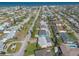 Aerial view of the neighborhood with tidy streets, houses, green trees, and the ocean in distance at 44 Sunset Blvd, Ormond Beach, FL 32176