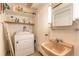Compact laundry room with washer, dryer, utility sink and storage shelves at 44 Sunset Blvd, Ormond Beach, FL 32176