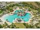 Aerial view of a large community pool featuring several palm trees and ample lounge seating at 464 Tropics Ave, Daytona Beach, FL 32124