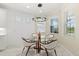 Bright breakfast nook with a glass table, modern lighting, and large windows offering natural light at 464 Tropics Ave, Daytona Beach, FL 32124