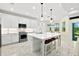 Bright and modern kitchen with white cabinets, stainless steel appliances, and a large island with seating at 464 Tropics Ave, Daytona Beach, FL 32124