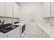 Modern laundry room features cabinets, counter space, stainless steel sink and new appliances at 464 Tropics Ave, Daytona Beach, FL 32124