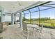 Relaxing screened patio with ceiling fans, and white table and chairs with stunning views of the grassy lawn at 464 Tropics Ave, Daytona Beach, FL 32124