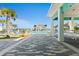 Stunning view of the pool area with lounge chairs, tiki huts, palm trees, and the ocean in the background at 464 Tropics Ave, Daytona Beach, FL 32124