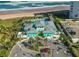 Aerial view of community pool with ocean view and covered seating area, plus parking and beachfront access at 464 Tropics Ave, Daytona Beach, FL 32124