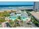 Aerial view of community pool with ocean view and covered seating area, plus ample beachfront access at 464 Tropics Ave, Daytona Beach, FL 32124