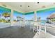 Elegant poolside bar area with high top tables and views of the pool, tiki huts, ocean, and palm trees at 464 Tropics Ave, Daytona Beach, FL 32124